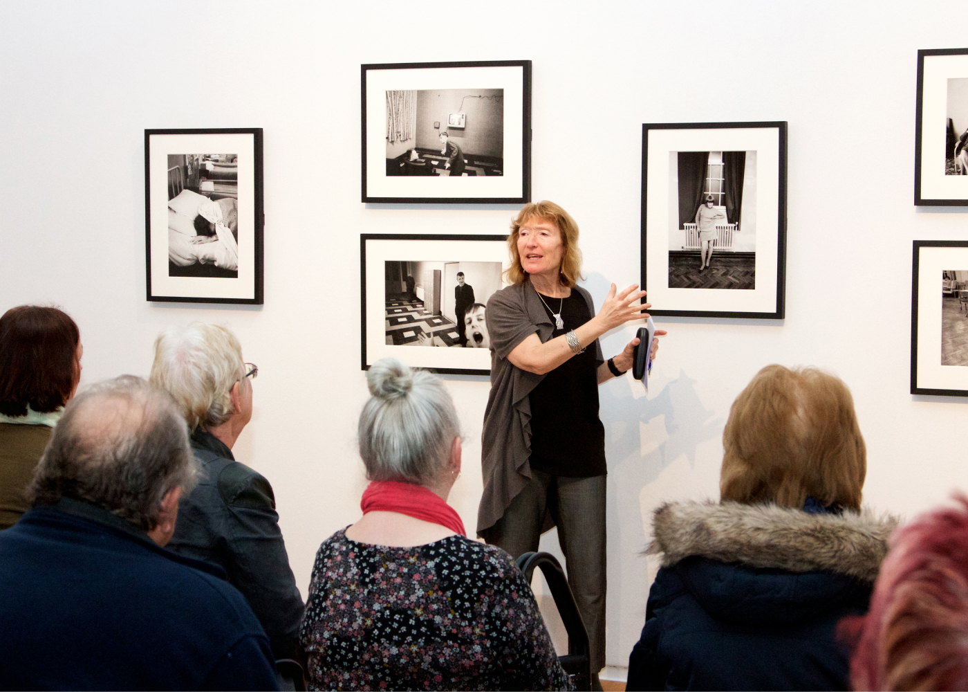 Anne Hornsby audio describing photographs by Martin Parr at an exhibition at Manchester Art Gallery to a group from Henshaws