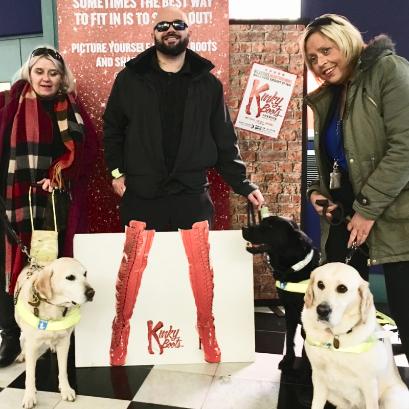 A blind attender poses with the photograph of red Kinky Boots at the touch tour for the show at the Regent Theatre, Stoke