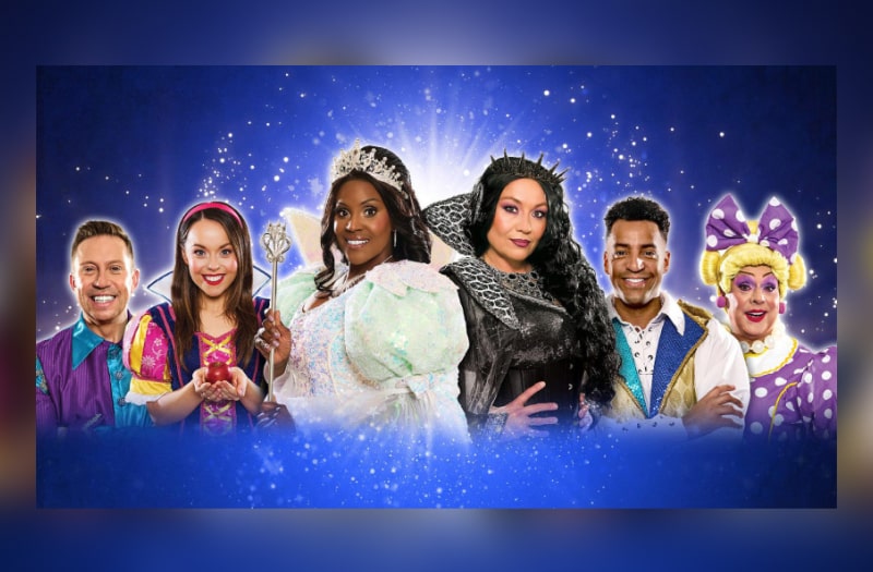 The image for Snow White shows the cast in costume arrayed head and shoulders against a sparkly deep blue background. Centre left is Kelle as the Good Fairy. They smile except for Niki.
