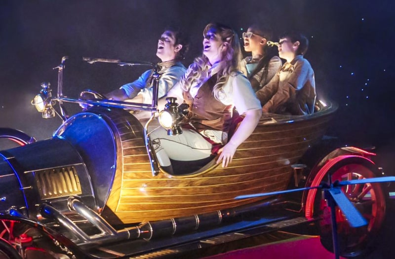 A production photograph shows Chitty in flight, chrome gleaming, red and yellow wings spread out, the Potts family in the seats awestruck against the background of a dark starry night.